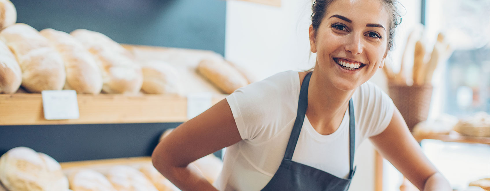 Smiling baker in a bakery setting. 