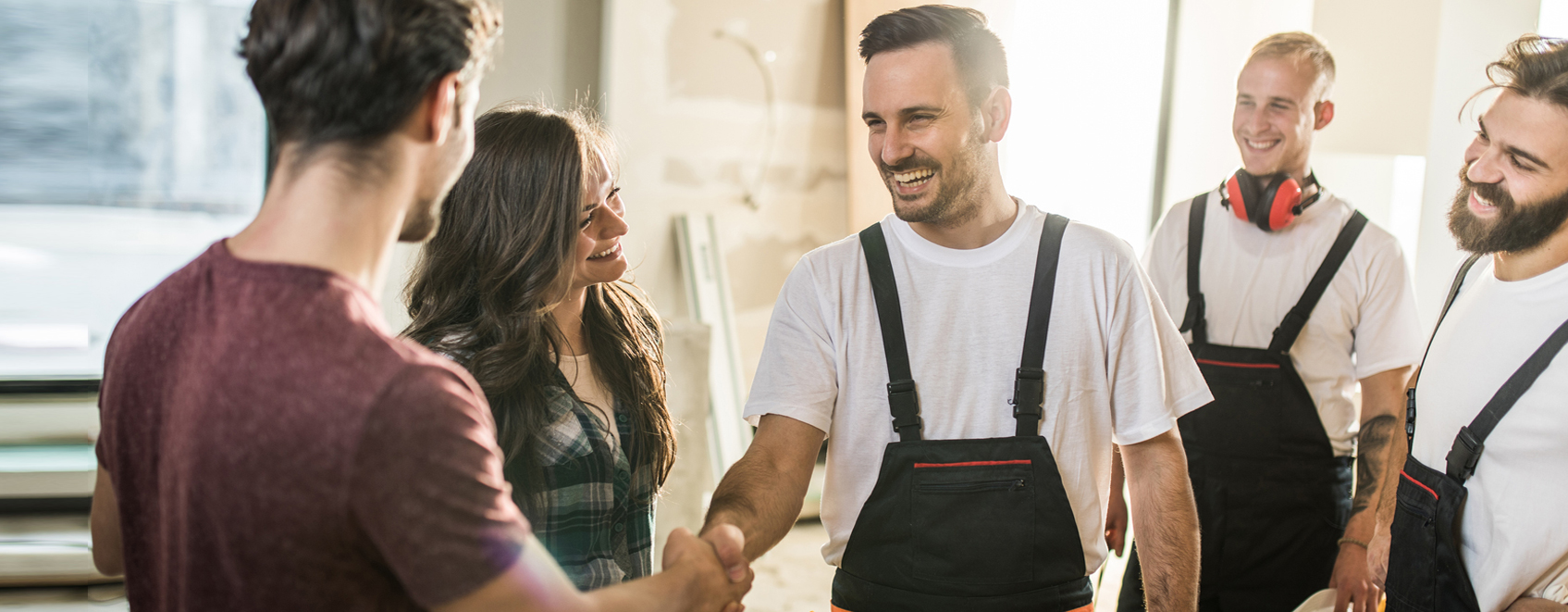 Contractors shaking hands with local business owners in-between work